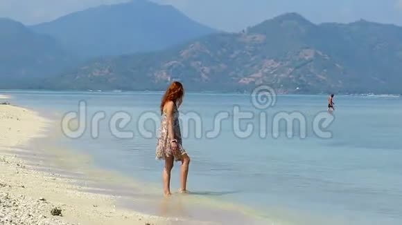穿着夏装的女孩走在美丽的海滩上视频的预览图