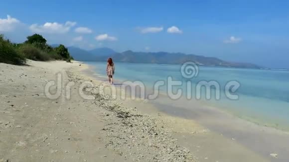 穿着夏装的女孩走在美丽的沙滩上视频的预览图