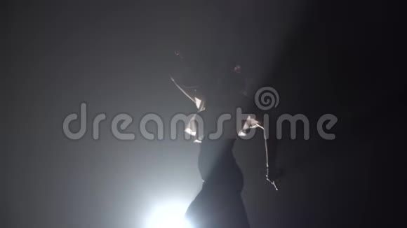 女孩手里拿着石膏跳舞从后面的光烟雾背景慢动作视频的预览图