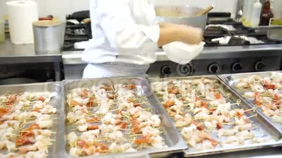 一个女厨师在虾串上放些香料4K视频的预览图