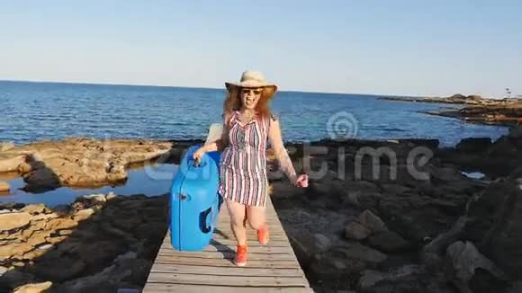 一个戴帽子的年轻女人手里拿着一个手提箱跑着视频的预览图
