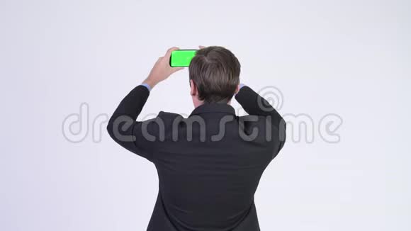 年轻商人用电话拍照后景视频的预览图
