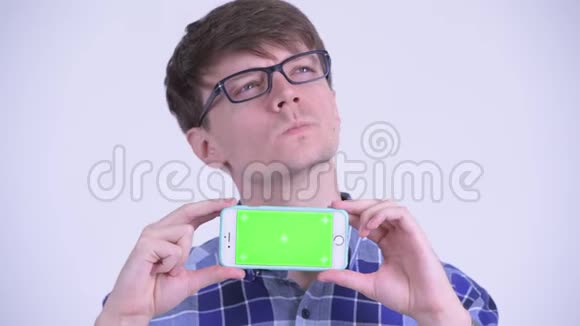 一个年轻快乐的时髦男人一边看手机一边思考视频的预览图