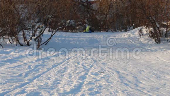 在晴朗的冬日女孩从雪管滑下山坡视频的预览图