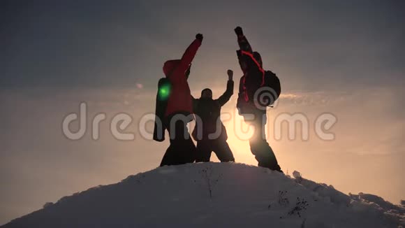 游客们来到雪山顶上在黄色日落的背景下为胜利而欢欣鼓舞游客的团队合作和视频的预览图