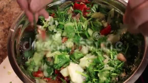 厨师把蔬菜沙拉的原料混合在碗里在碗中加入搅拌蔬菜沙拉混合配料视频的预览图