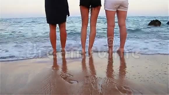 一群赤脚在海岸边行走的朋友的腿视频的预览图
