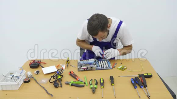 在车间电工使用剪线刀切割一块电线两个人宽敞明亮的工作室工作视频的预览图