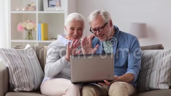 一对老夫妇在家里用笔记本电脑聊天视频的预览图