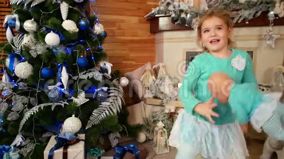 圣诞快乐小女孩在装饰壁炉旁跳舞小女孩带着洋娃娃跳舞视频的预览图