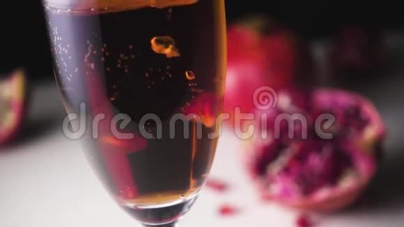 石榴籽颗粒在香槟中慢慢滑落视频的预览图