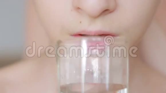 儿童用杯子喝纯净水的特写镜头视频的预览图