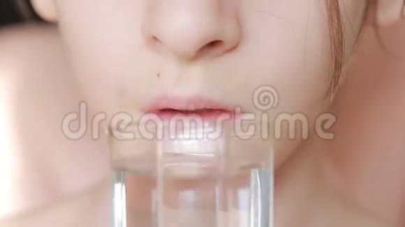 儿童用杯子喝纯净水的特写镜头视频的预览图