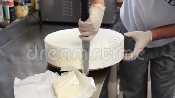 一个男厨师准备结婚蛋糕的基础在上面撒些黄油4K视频的预览图