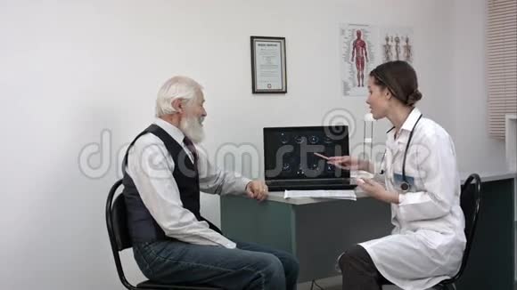 医生在笔记本电脑上显示核磁共振并告诉老年病人好消息视频的预览图