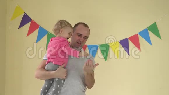 年轻快乐的父亲抱着小女儿他们在家跳舞视频的预览图