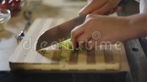 女人手在砧板上切绿色蔬菜沙拉素食视频的预览图