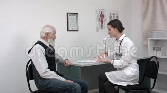 医生和她的男性老年病人谈话并写了些东西视频的预览图