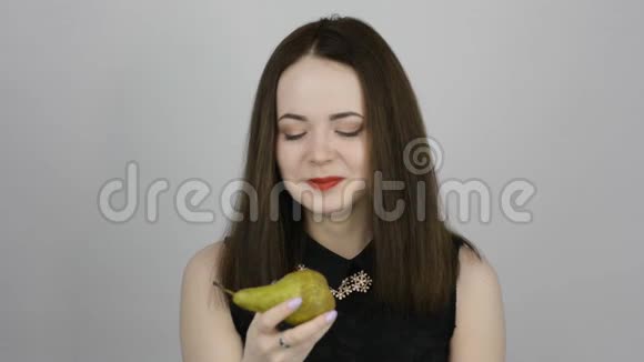 年轻女子吃着绿梨微笑着视频的预览图