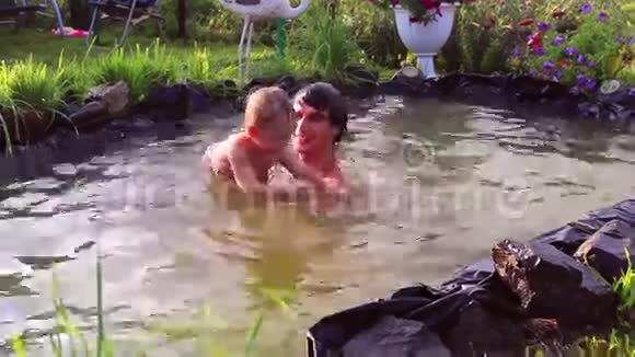 年轻人在池塘里和一个小孩玩视频的预览图
