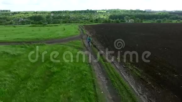 从村里骑自行车穿过田野的女孩视频的预览图
