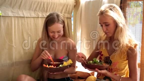 两个有魅力的女孩在度假吃纯素食品视频的预览图