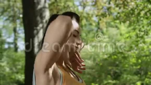 年轻女子在公园里举起双臂享受大自然视频的预览图