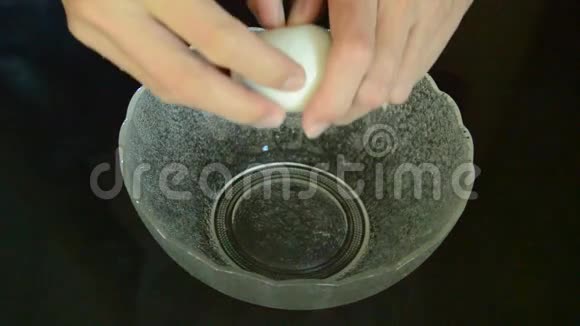 厨房柜台上的玻璃碗里手上裂开的白色蛋壳视频的预览图