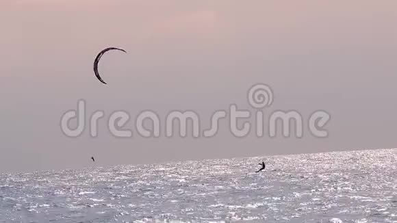 日落时风筝冲浪日落时一个人在海里风筝冲浪视频的预览图
