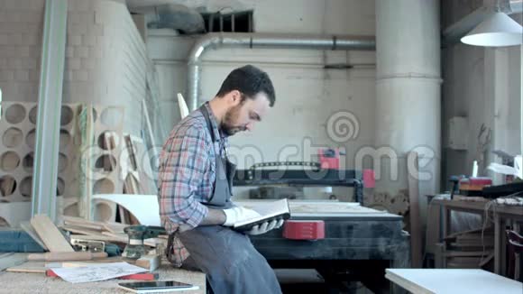长胡子的木匠在他的车间读日记视频的预览图
