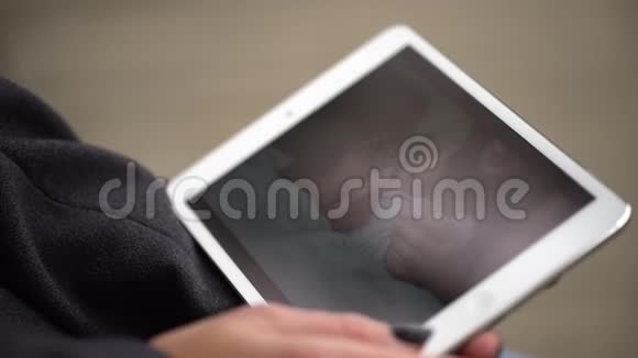 在秋天公园坐在长凳上时年轻的女人用平板电脑女性手触摸平板电脑的特写视频的预览图