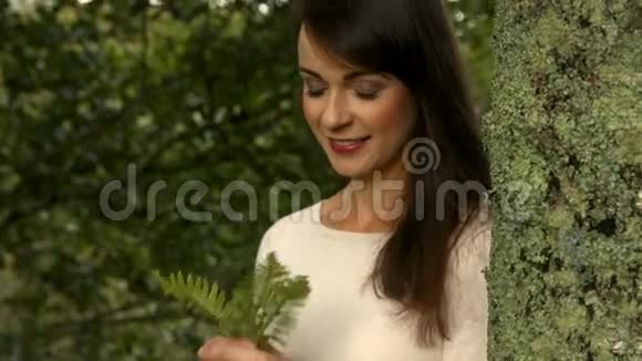 闻树叶的漂亮女孩视频的预览图