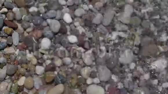 海滩上的圆卵石和透明的波浪视频的预览图