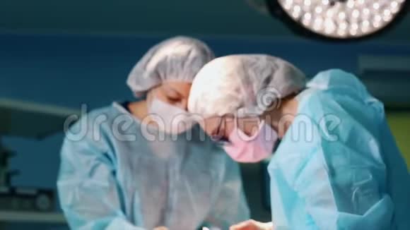 在手术室两个外科医生在手术中现代医院的专业医生整形外科手术视频的预览图