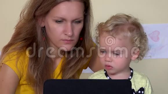 严肃的脸女人用平板电脑教女婴特写视频的预览图