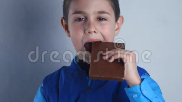 男孩吃巧克力微笑九岁男孩吃甜的视频的预览图