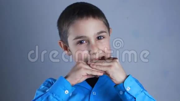 男孩吃巧克力微笑九岁男孩吃甜的视频的预览图