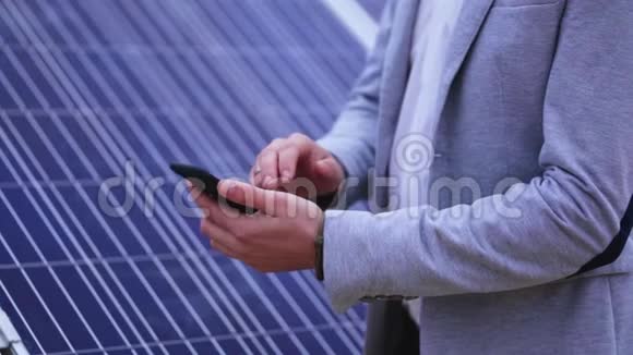 在太阳能电池板背景下一名手持电话的男子的手视频的预览图