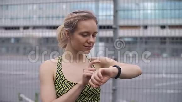 慢跑的女人检查她的健身手镯视频的预览图