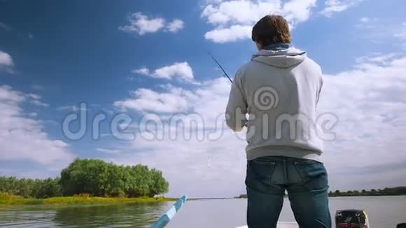 渔夫从河上的一艘船上钓到一条鱼在伏尔加河三角洲的船上钓鱼的人视频的预览图