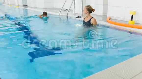 老师和孩子在游泳池里做运动教练教女孩子游泳视频的预览图