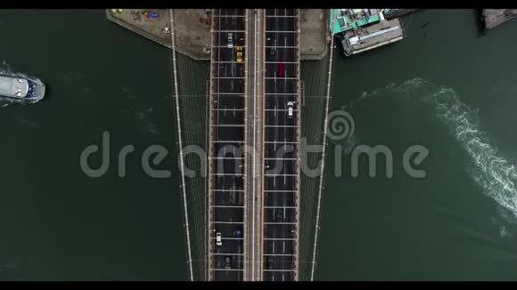 布鲁克林大桥上的鸟眼直升机和漂浮在桥下的船视频的预览图