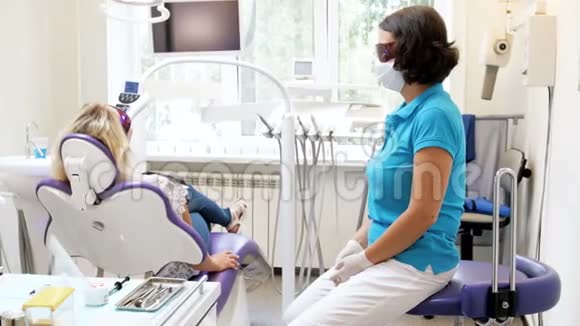 牙科医生在牙齿美白过程中与病人坐在一起的4k录像视频的预览图