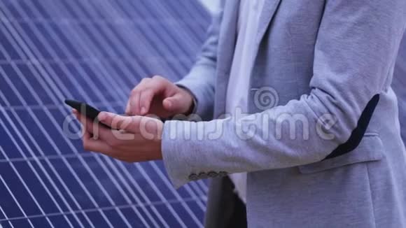 在太阳能电池板背景下用手机特写视频的预览图