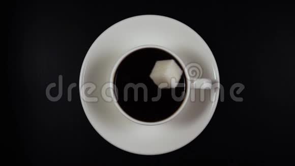 一块糖在杯子里掉进咖啡里缓缓移动俯视视频的预览图