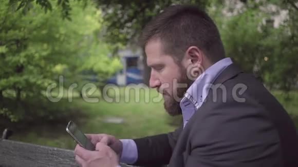 商人用智能手机写短信户外视频的预览图