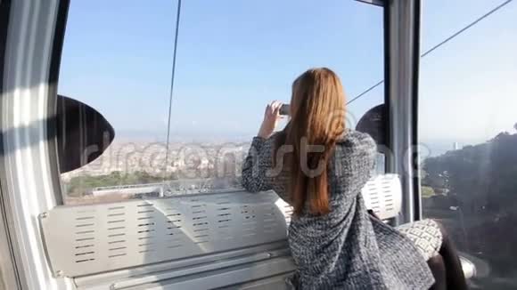 一位坐在沙发上的女士拍摄城市景色视频的预览图