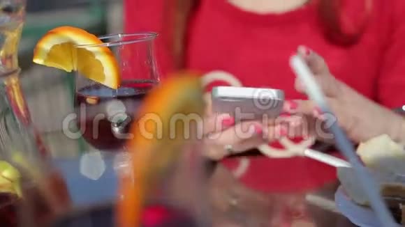 女性手拿智能手机和红酒视频的预览图