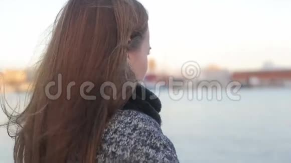 女性转向相机在船帆的日落灯光下视频的预览图