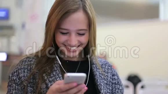 航空站的女乘客在听智能手机上的东西女孩微笑并使用她的小玩意的触摸屏视频的预览图